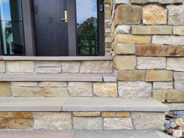 closeup of neutral and warm toned natural stone veneer with matching stair treads