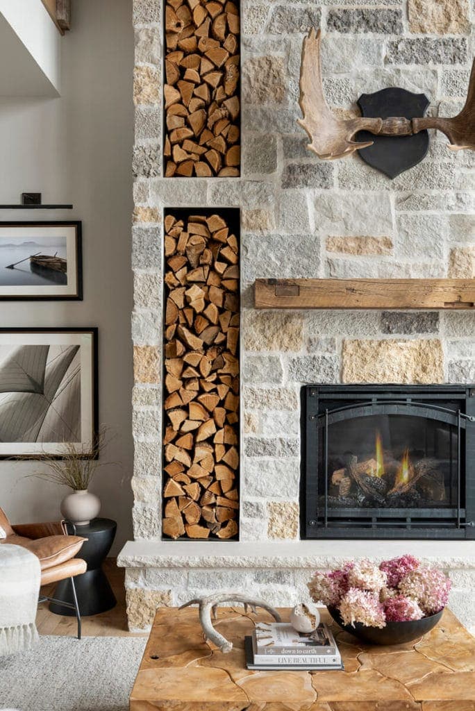 residential fireplace featuring light colored natural stone and wood accents