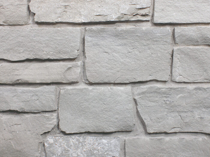 closeup of blacksmith split face natural stone veneer display with standard grey mortar