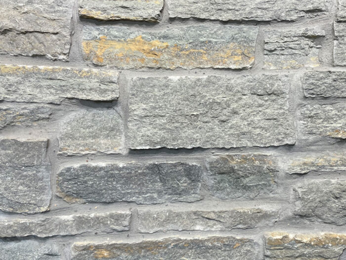 closeup of blue river variegated natural stone veneer display with standard grey mortar