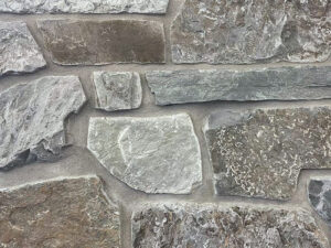 closeup of castle mountain natural stone veneer display with standard gray mortar