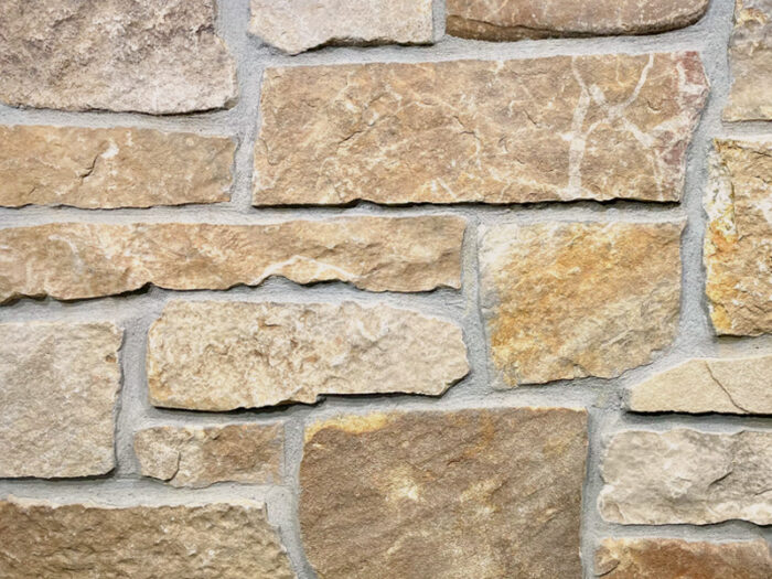 closeup of chestnut ashlar natural stone veneer display with standard grey mortar