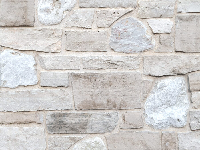 closeup of country cottage natural stone veneer display with white mortar