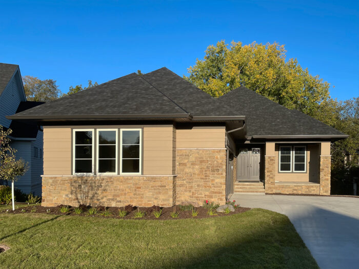 photo of a tan home with brown and gold natural stone veneer on the exterior