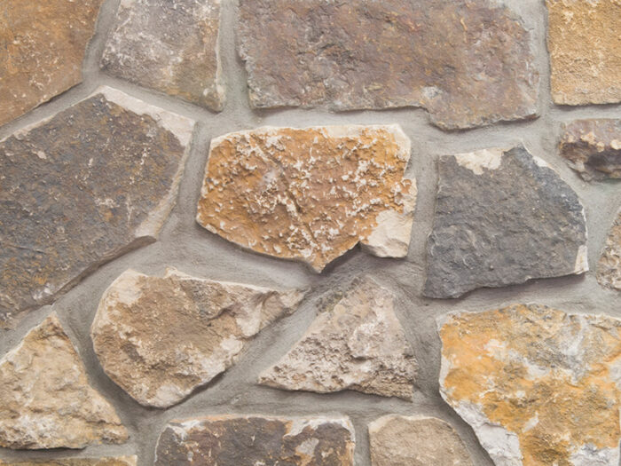 closeup of desert tortoise natural stone veneer showroom display with standard grey mortar