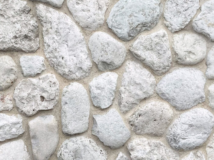 closeup of door county cobble natural stone veneer display with white mortar