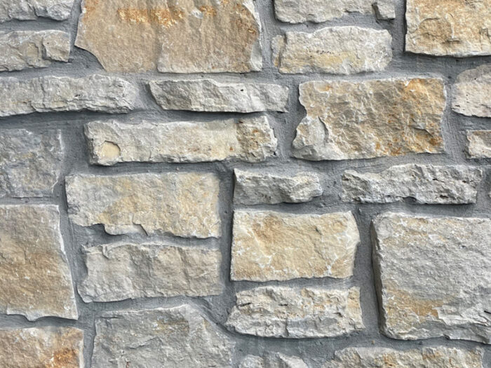 closeup of fond du lac rustic natural stone veneer display with standard grey mortar
