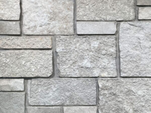 closeup of fond du lac tailored natural stone veneer display with standard grey mortar