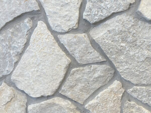 closeup of fond du lac web wall natural stone veneer display with standard grey mortar