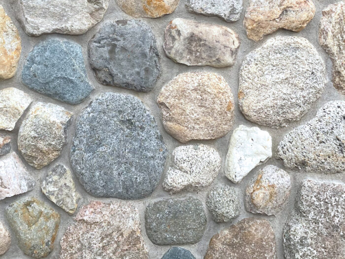closeup of Granite Cobble natural stone veneer display with standard grey mortar