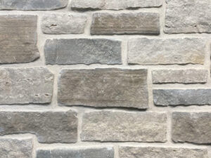closeup of grey gull cottage natural stone veneer display with white mortar