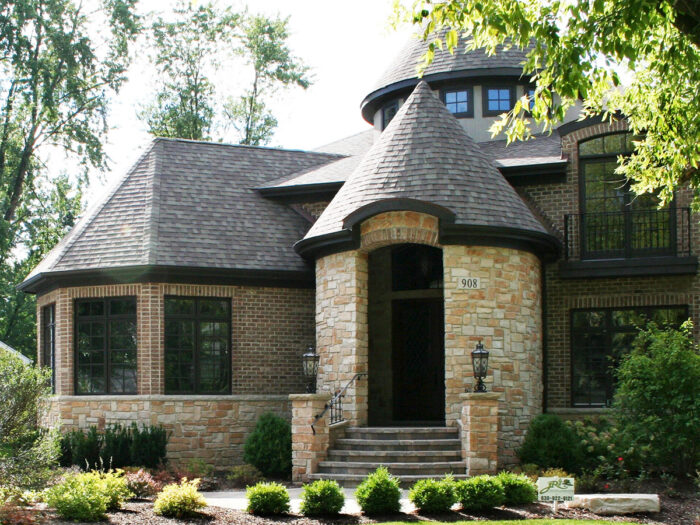 image of a home exterior with neutral and gold natural stone and red brick exterior