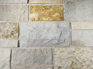 closeup of ideal buff castle natural stone veneer display with a black and white mortar mix
