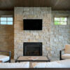 three season porch with wall to wall natural stone and floor to ceiling fireplace