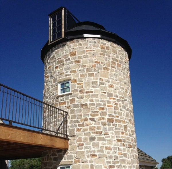 neutral colored natural stone silo with balcony and windows