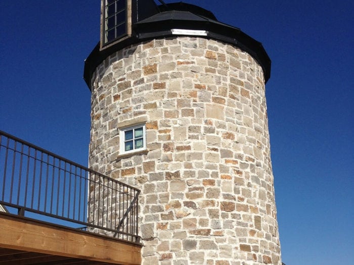 neutral colored natural stone silo with balcony and windows