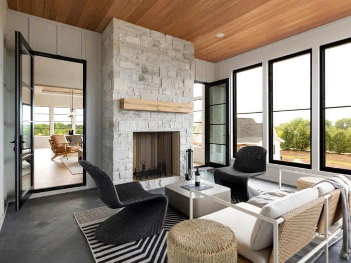 modern sunroom featuring a white stone fireplace