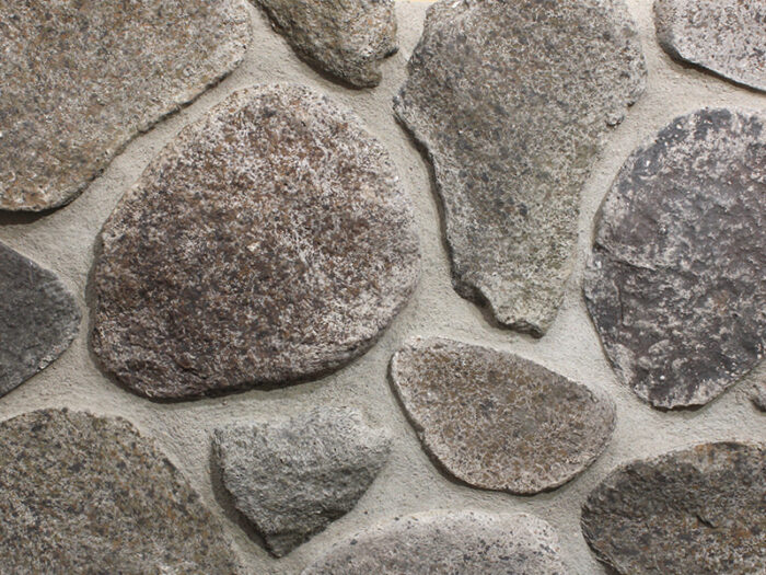 closeup of minnesota split fieldstone manufactured stone veneer display with standard grey mortar