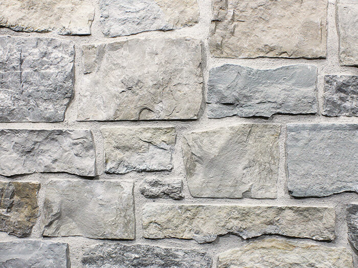 closeup of mountain ridge machine chopped natural stone veneer display with white mortar