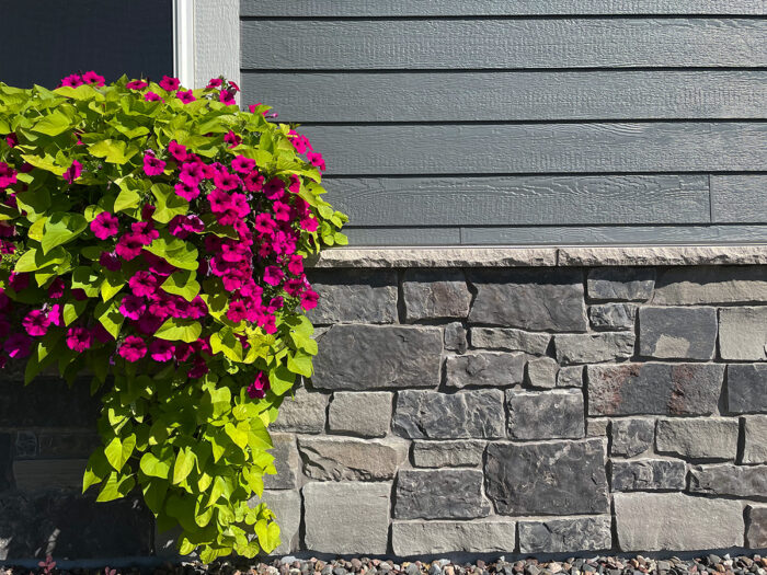 close up image of a grey natural stone blend installed in a wainscot with an indiana limestone sill