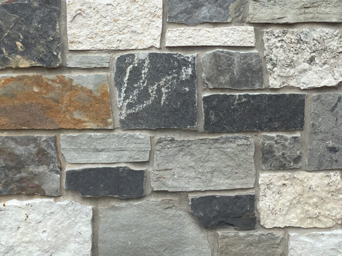 closeup of ravensmoor manor natural stone veneer display with standard grey mortar
