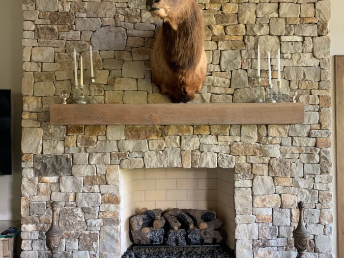 large indoor fireplace with cream colored stone surround and hearth