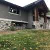 image of a home exterior featuring a cream and grey natural stone wainscot and matching pillars