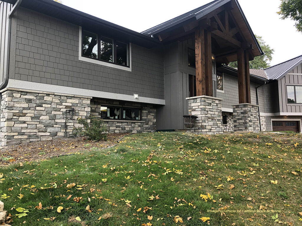 image of a home exterior featuring a cream and grey natural stone wainscot and matching pillars