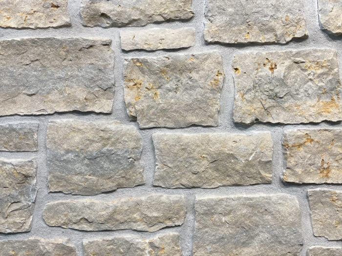 closeup of sandy bay splitface natural stone veneer display with restoration mortar