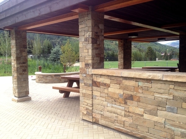 outdoor pavilion with tan stone walls and pillars