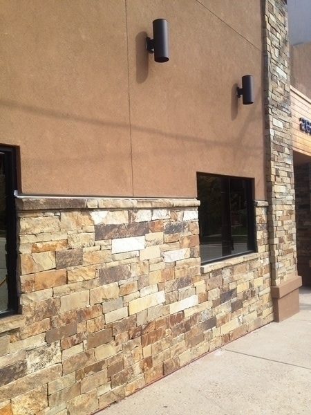building exterior with brown stucco and brown toned stone wainscot and pillar