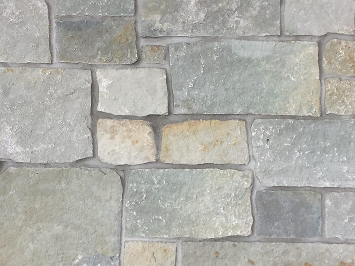 closeup of stone harbor bedface natural stone veneer display with standard grey mortar