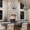 residential kitchen with a tall, counter-to-ceiling fireplace veneered with stone harbor splitface tumbled veneer