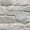 closeup of stone harbor splitface tumbled natural stone veneer display with white mortar
