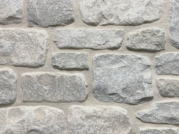 closeup of stone harbor splitface tumbled natural stone veneer display with white mortar